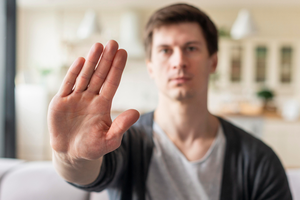 Man holding his hand up as a barrier